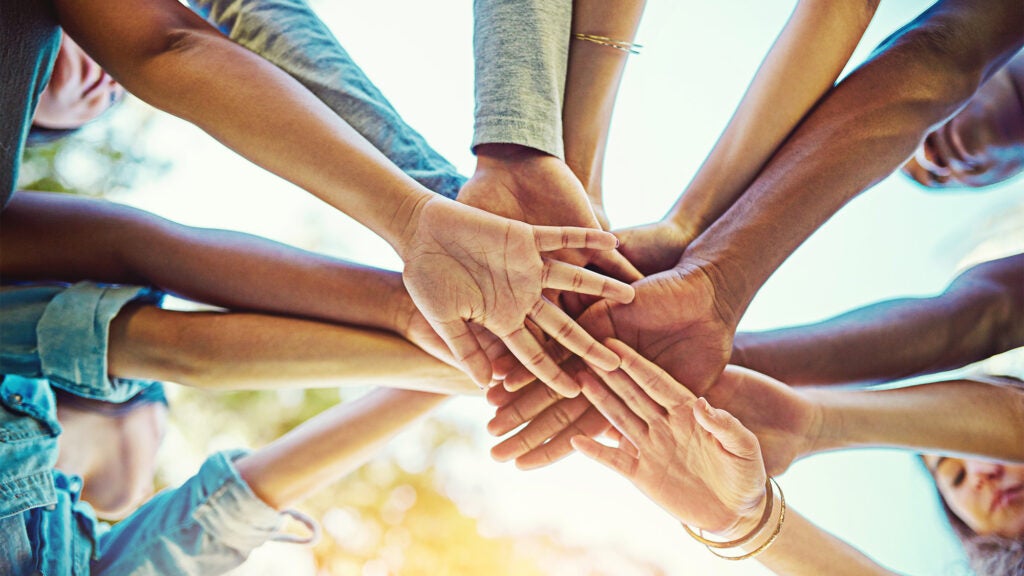 A group of people stack hands in a show of support