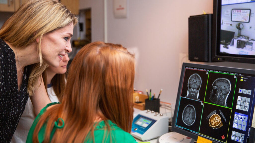 A professor advises a student as they look at a brain scan