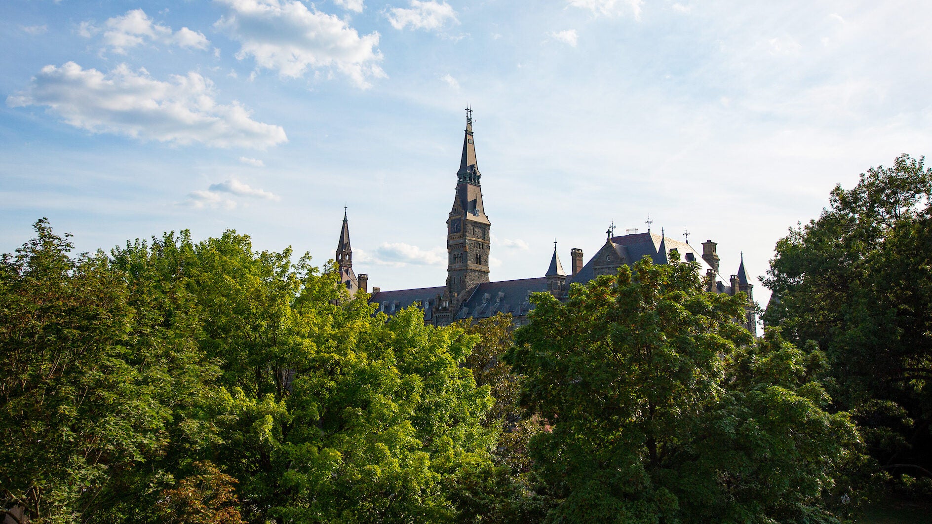 Healy Hall from afar through the green trees