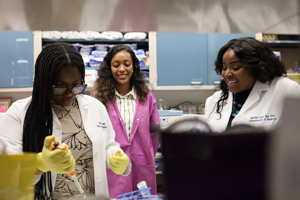 Three individuals work in a lab